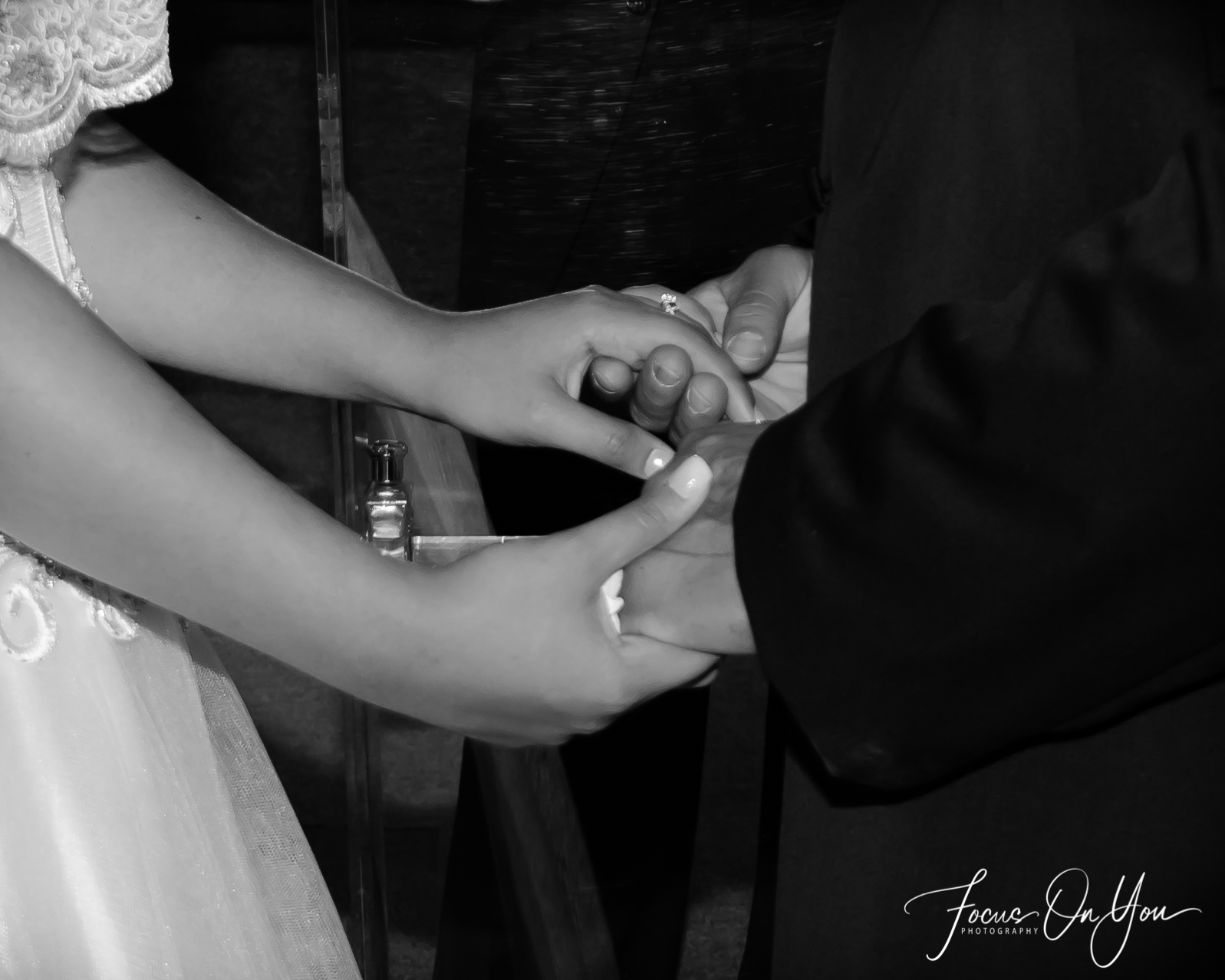 Bride and groom placing wedding bands on hands